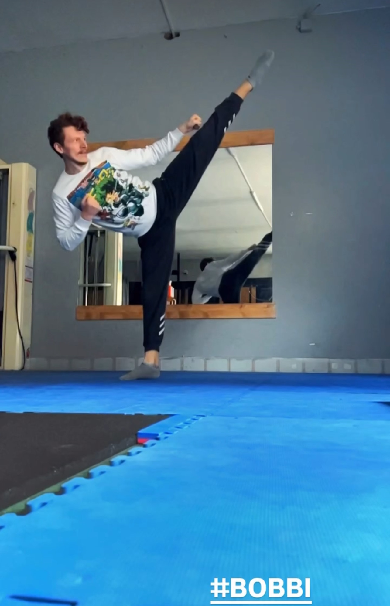 Vladyslav esegue un calcio alto durante una pratica sul tatami.